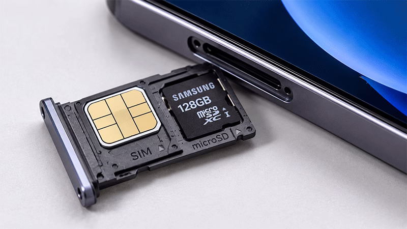 Detalhe aproximado de uma bandeja de chip de smartphone removida com espaço para cartão de memória MicroSD.