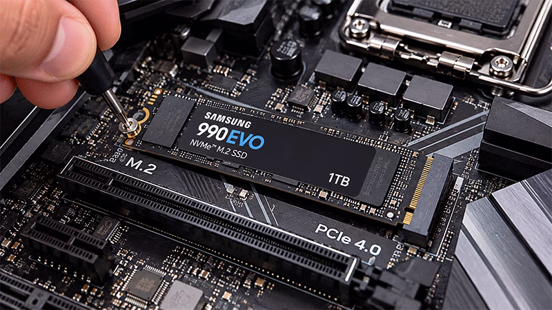 Mão instalando com cuidado um SSD NVMe no slot M.2 de uma placa-mãe de computador desktop.